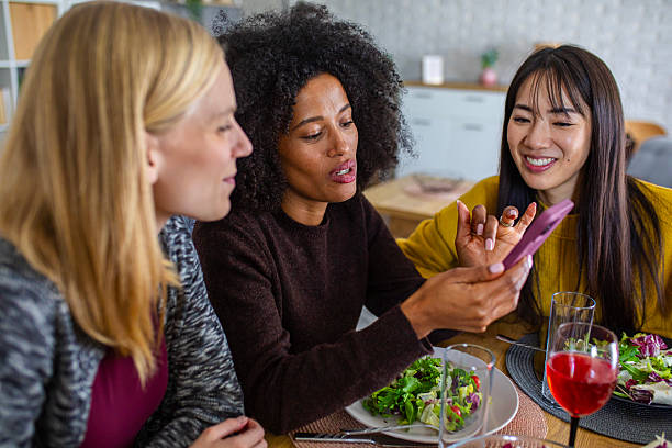 istock A joyful group of women share a laugh at the dining table while checking a smartphone during their meal 2255276232