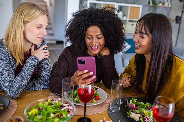 istock A joyful group of women share a laugh at the dining table while checking a smartphone during their meal 2255276242