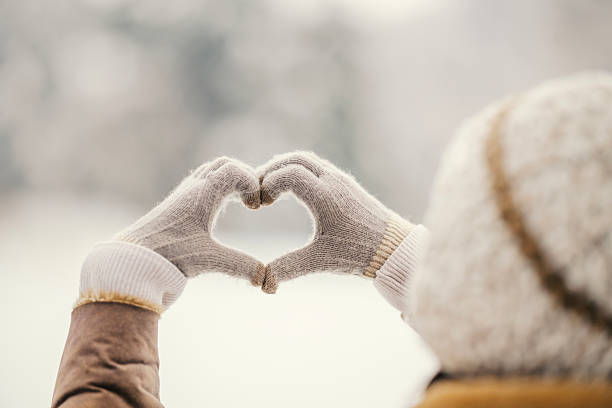 istock Person making heart hand sign in winter 2255277529