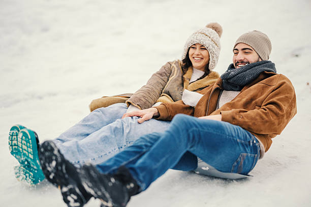 istock Happy smiling couple sledding down snowy hill 2255278209