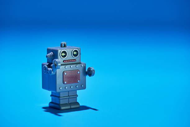 small toy bobot against blue background
