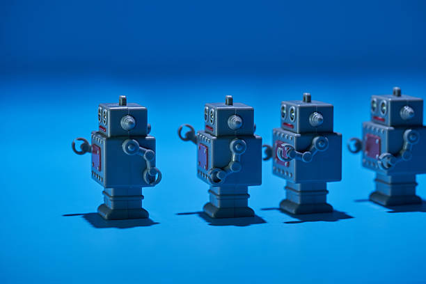 small toy bobot lined up against blue background