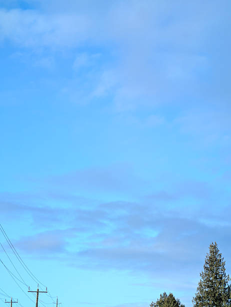 A line of clothes hanging on a clothesline. The clothes are white and are drying in the sun