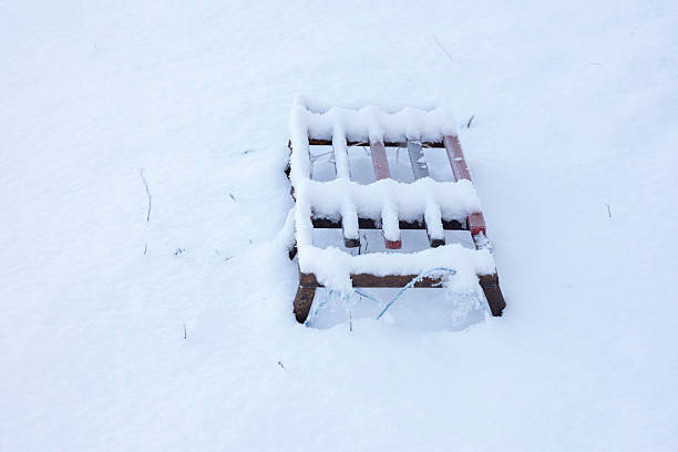 istock Wooden pallet covered in white snow during winter 2255293492