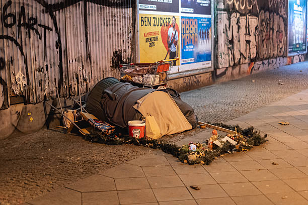 One man, young homeless man playing acoustic guitar on the street and begging.