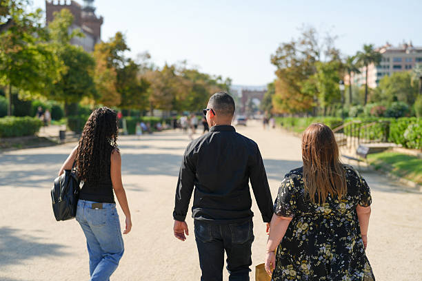 istock Three people walking down a street, one of them is holding hands with another 2255311190