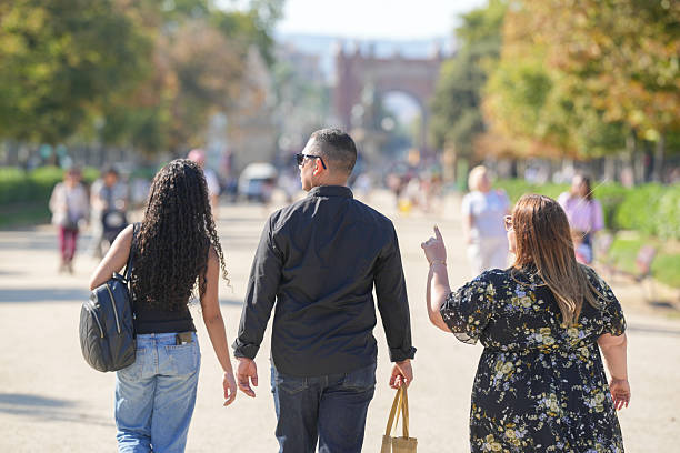 istock Three people walking down a street with a man pointing to something 2255311321