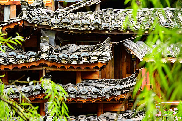 A traditional Miao village building in Guizhou, showcasing the distinct brownish-yellow fir timber framework and the layered gray ceramic roof tiles, embodying the rustic and harmonious architectural style of the local ethnic culture.