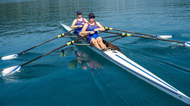 istock Young Female Athletes Rowing on Pristine Lake with Focus 2255313712