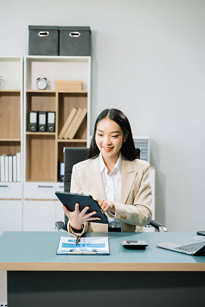 istock Confident Asian woman with a smile standing holding notepad and tablet 2255318972