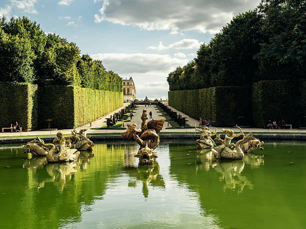 Sculptures and fountain in the formal gardens of the Palace of Versailles, a historic French heritage site near Paris, France.