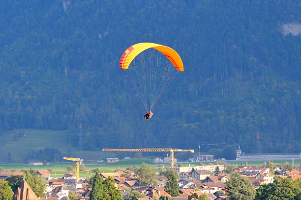 Interlaken, Switzerland-Oct.1st 2025: Tandem paraglider flying over Interlaken town