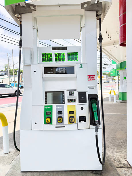 Front view of a single fuel pump dispenser standing on the concrete forecourt of a modern gas station, showing digital price display, multiple colored fuel nozzles and clean petroleum retail infrastructure with no people or cars visible.​Ideal for use in articles and ads about fuel prices, petrol and gas industry, transportation costs, energy markets, road travel, service station branding, convenience store marketing and environmental discussions around fossil fuels.​