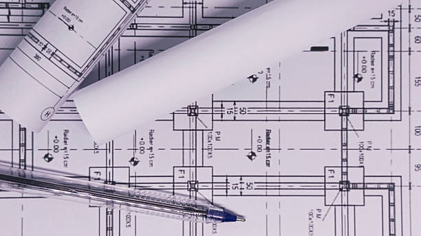 istock Architectural blueprints with rolled plans and pen on desk 2255327695
