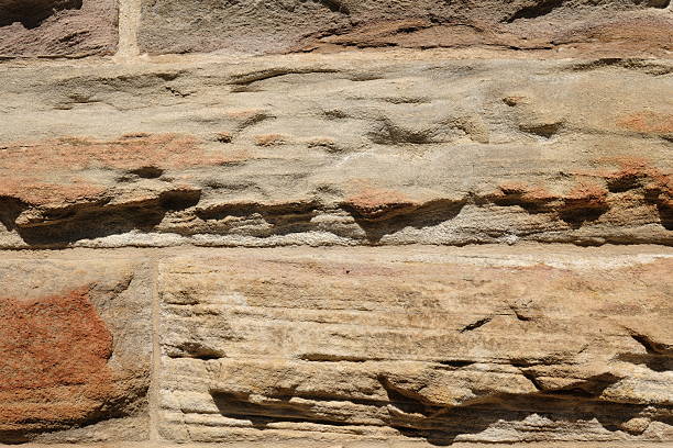 Old weathered sandstone block wall