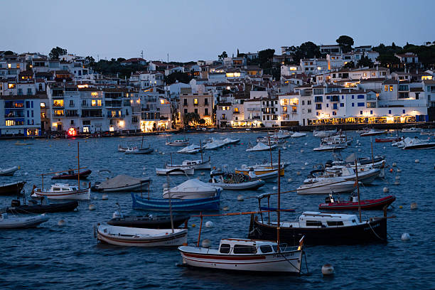 Night view of boats and illuminated buildings in the small fishing village of Cadaques curving around a bay in the Mediterranean Sea, Costa Brava, Catalonia, Spain