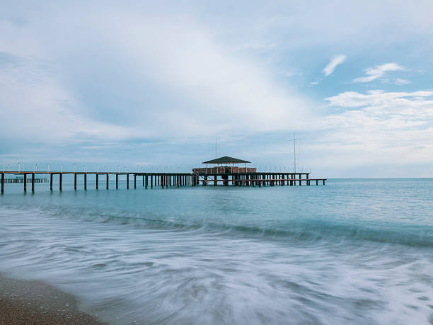 peaceful ocean waves near an old pier at sunset