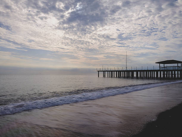 peaceful ocean waves near an old pier at sunset