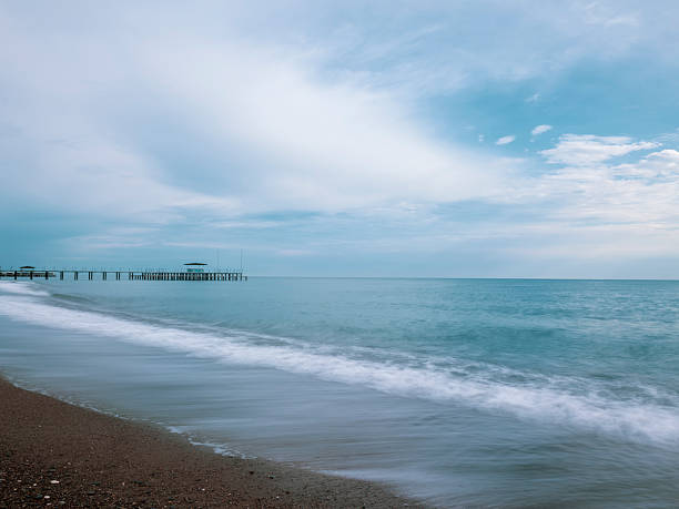 peaceful ocean waves near an old pier at sunset