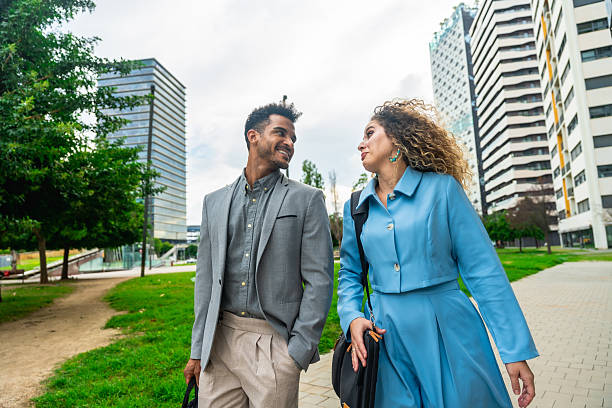 istock Colleagues walking and talking in city park 2255340544