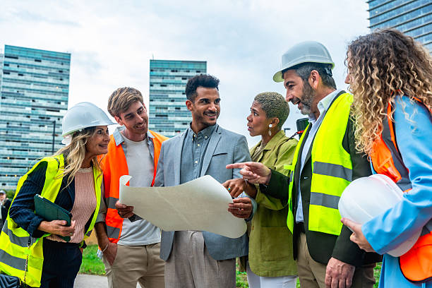 istock Diverse construction team discussing blueprint at urban building site 2255340720