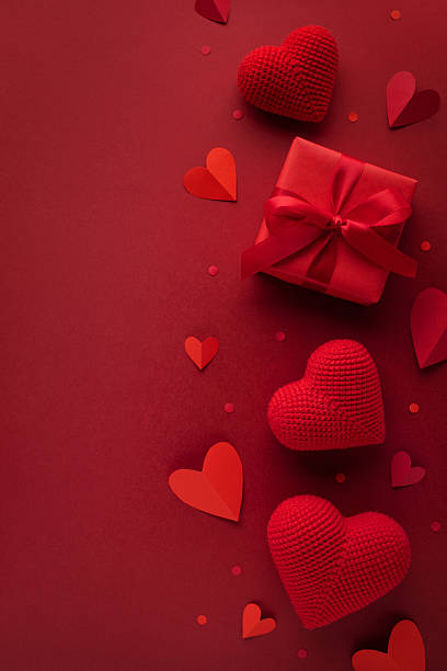 istock Valentine's Day vertical card with love hearts and gift box on red background top view. 2255341398