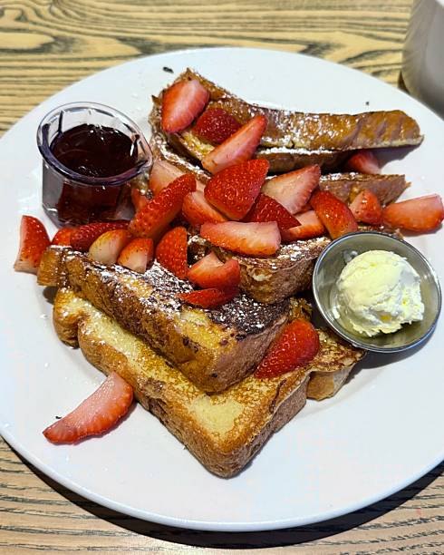 Golden French toast topped with fresh strawberries, offering a soft, custardy texture and gentle sweetness. Warm, inviting, and visually appealing, perfect for cozy breakfast or brunch moments.
