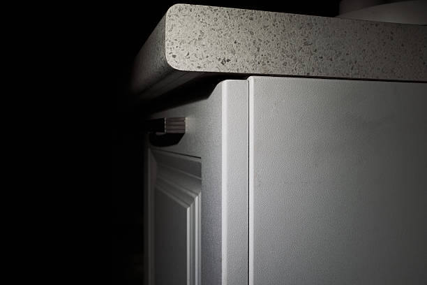 Minimalist kitchen countertop and cabinet with modern design in dim lighting.