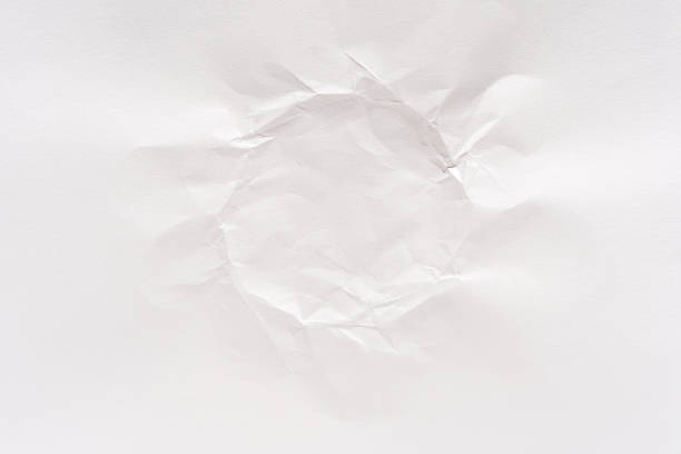 Crumpled torn hole in blank white paper with light shadow detailing in a minimalistic abstract design.