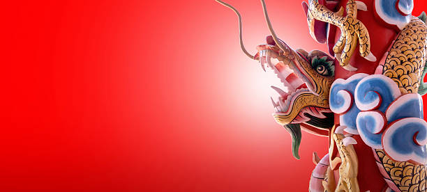 Image of elaborately decorated dragon sculpture adorns a pillar against red background.