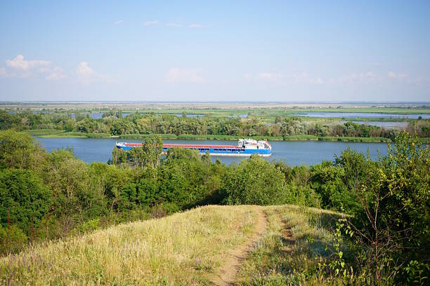 A barge is sailing on the Don River. Natural landscape with green trees.