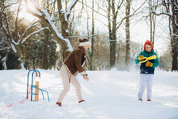 Children are walking, hiking,, sledding and playing in a snowy park. Winter fun and outdoor activities with kids