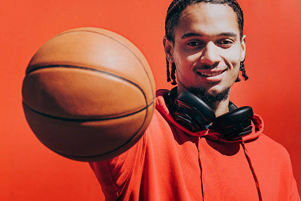 istock young smiling sportsman holding basketball to camera 2255356708