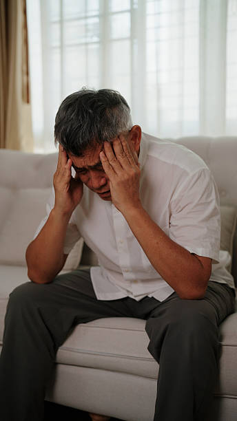 istock Asian elderly man struggling with constant head pain and deep mental pressure 2255358437
