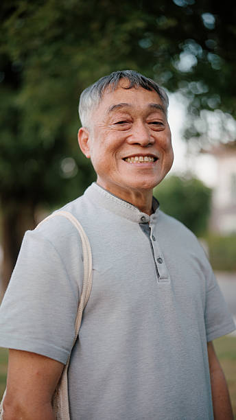 istock Smiling Asian senior man looking at the camera outdoors in a park 2255358614