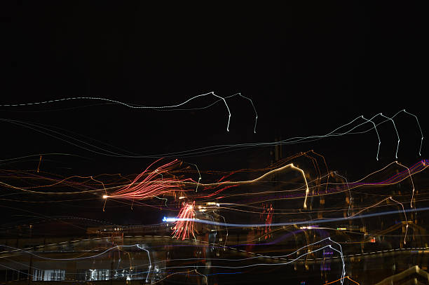 Artistic motion-blurred shot of New Year fireworks over the Saburtalo district in Tbilisi. The streaking lights and soft colors create a dreamy, abstract interpretation of the festive celebration.