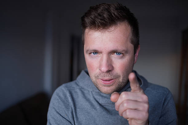 Displeased male boss pointing finger, blaming or warning the viewer. High quality photo