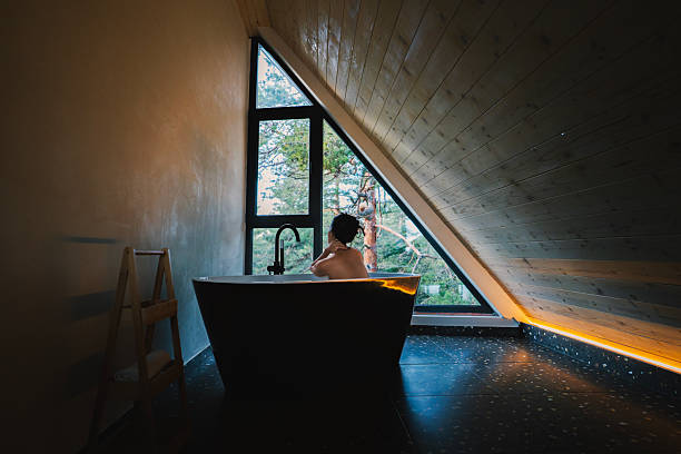 Candelaria, Cuba-October 9, 2019: Bathtub next to the window of a tiled-to-the-ceiling bathroom with views overlooking Lago San Juan Lake in a local house of Las Terrazas rural tourist eco-community.