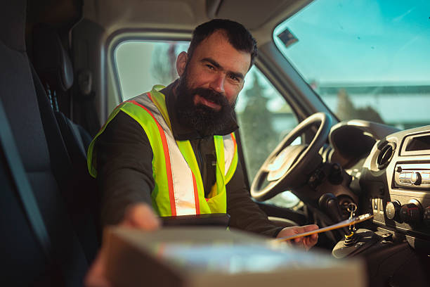 istock Friendly Delivery Driver Handing Over a Package from the Driver’s Seat 2255370264