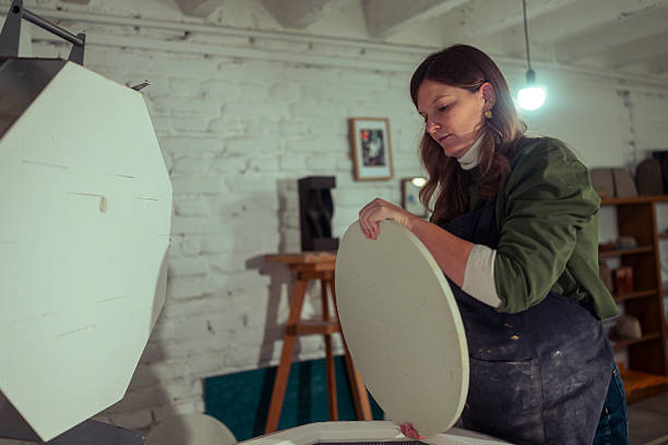 istock Ceramic artist carefully arranging unfinished clay vessels inside a kiln 2255370664