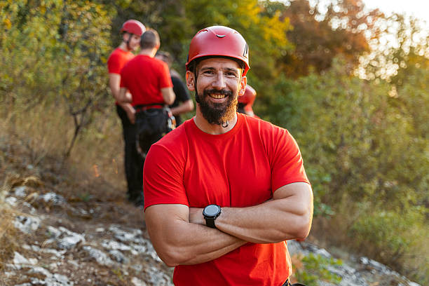 Portrait of a mountain rescuer on the mountain. Behind him is his team.