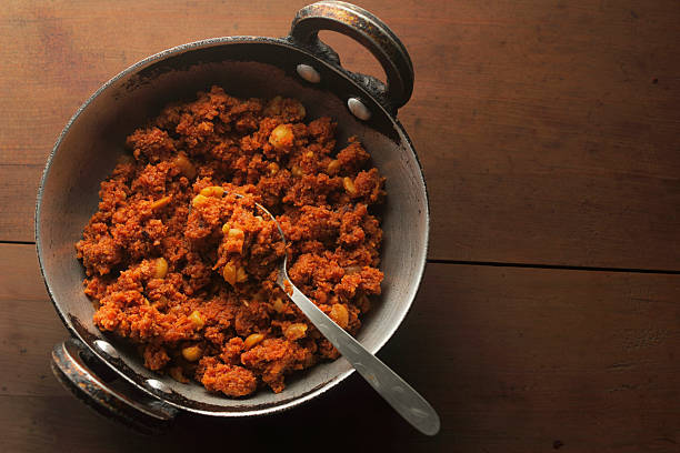 Overhead view of carrot halwa inside a traditional Indian kadai, showing the rich color and homemade cooking style.