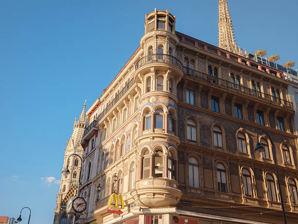 Architectural detail of a historic residential building in Vienna, Austria, with decorative facade, towers, and classic European style under blue sky.