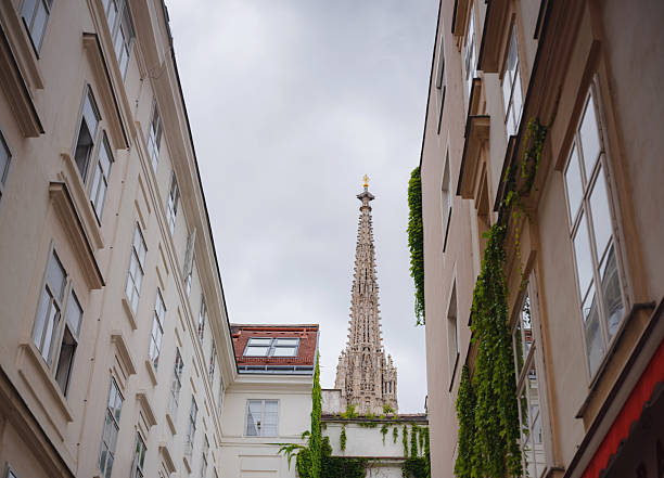 view from street on Historic Saint Stephens Cathedral on Stephansplatz square during summer day in Vienna. Tourists walk near Gothic architecture landmarks of Austrian capital city.