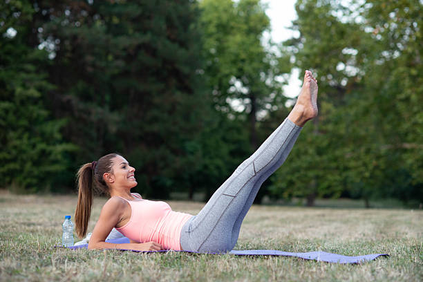 Smiling young woman exercising in the nature on a sunny summer day.