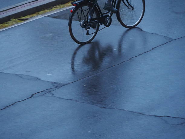 Reflection of a bicycle in a puddle during a rainy day in autumn.