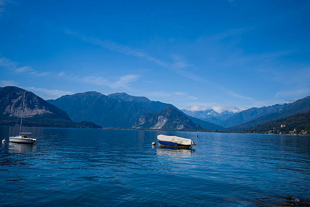 Boat Moored On The Shore With A Cityscape In The Background