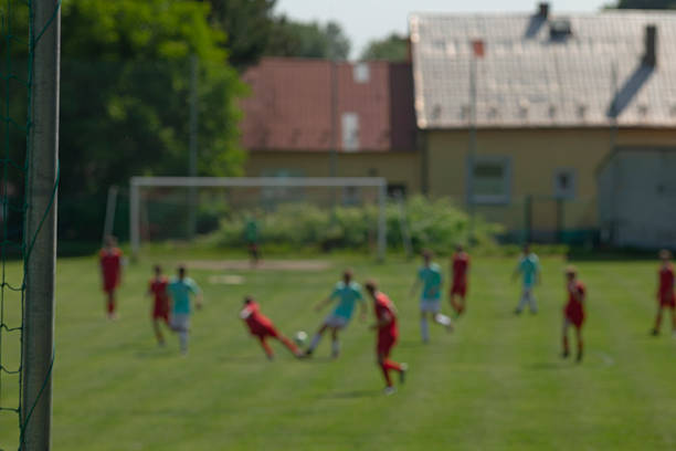 Players launching fast attack toward opponent goal with sprinting wingers and forward pressure, momentum and urgency on sunlit green pitch
