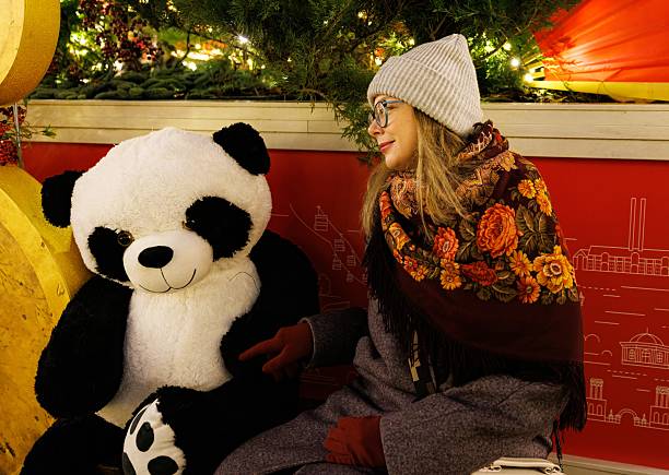 istock Creating joyful memories with a friendly panda plush during a winter evening in a festive setting 2255389578