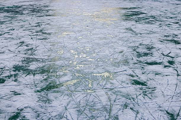 A sparkling ice surface is illuminated by the fading sunlight, showcasing intricate patterns under winter's charm.